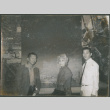 Agnes Sakura and two men standing by large photo(?) (ddr-densho-523-444)