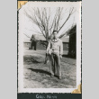 Man standing by tree holding books (ddr-densho-434-323)