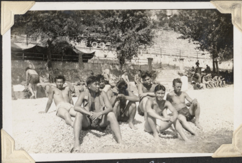 Group of men in bathing suits sitting on beach (ddr-densho-466-653)