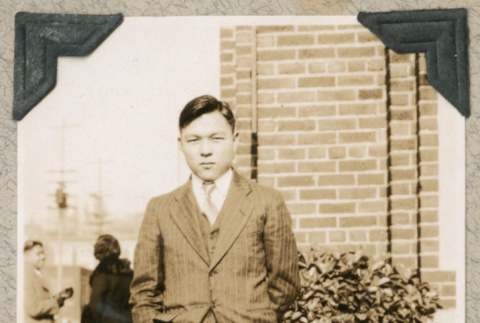 Jack Nakagawa in suit on sidewalk (ddr-densho-383-129)