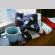 A folded American flag and mug (ddr-densho-336-1090)