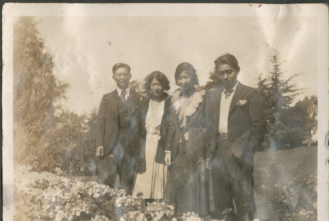 Four people standing by flower bed (ddr-densho-316-200)