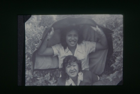 (Slide) - Image of two women huddled under jacket (ddr-densho-330-222-master-2cd4417f00)