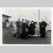 Rev. L. H. Tibesar posing with the Kinoshita family at gates of Camp Minidoka, Idaho (ddr-densho-403-8)