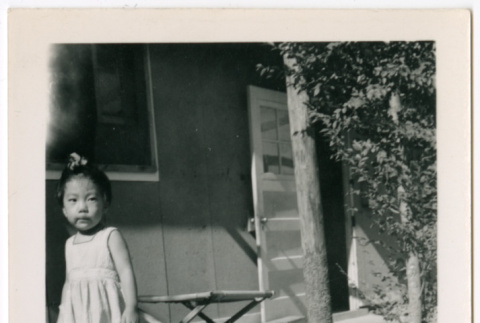 Girl standing by doorway of barracks (ddr-densho-329-1342)