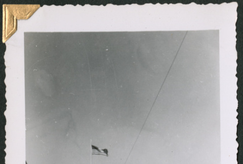 Man standing by tree and flag (ddr-densho-434-337)