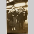 A woman carrying bouquets at train station (ddr-njpa-1-2519)