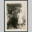 girl outside shed next to tall plants (ddr-densho-378-423)