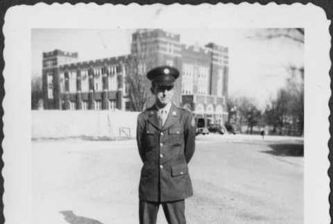 Man standing with large building in background (ddr-densho-434-452)