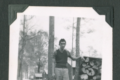 Man by log pile (ddr-densho-471-70)