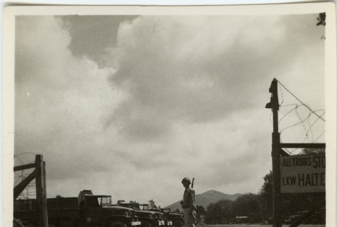 Soldier standing in front of military vehicles (ddr-densho-201-77)