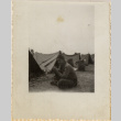 Man sitting on ground near tents (ddr-densho-466-370)