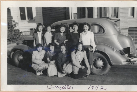 Group of women in front of a car (ddr-manz-10-1)