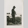 Larry Tajiri taking a photo on a rocky beach (ddr-densho-338-295)