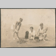 Two men, a woman and dog digging razor clams (ddr-densho-523-44)