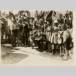A pilot kneeling with children and holding bouquets (ddr-njpa-1-2219)