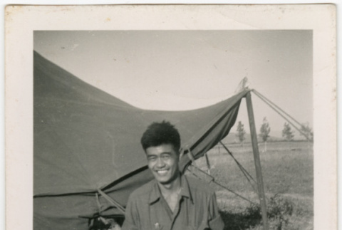 Saburo Arthur Kitagawa kneeling outside tent (ddr-densho-539-23)