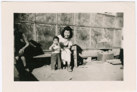 Women Sitting with Child outside barracks (ddr-densho-329-1362)