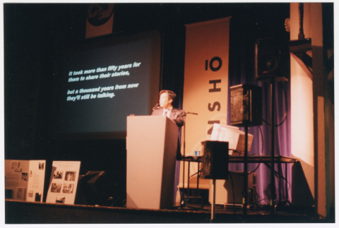 Tom Ikeda speaking on stage at the Densho Gala and giving a presentation (ddr-densho-506-135)