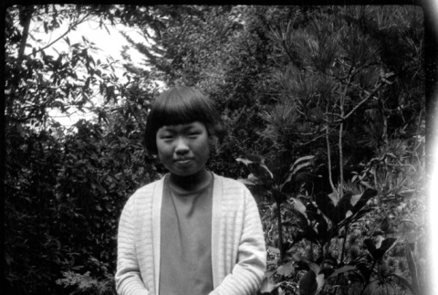 Girl in white sweater standing in garden (ddr-densho-426-2012)