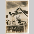 Tomoye (Nozawa) Takahashi on board ship, standing with man with violin (ddr-densho-426-1524)