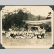 Group of children with U.S. flags posing in field (ddr-densho-483-519)