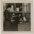 Man standing next to desk, woman seated at desk (ddr-densho-426-945)