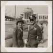 Women in Red Cross uniform standing with man in uniform next to car (ddr-densho-466-11)