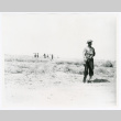 One soldier, marchers in background (ddr-densho-1007-417)
