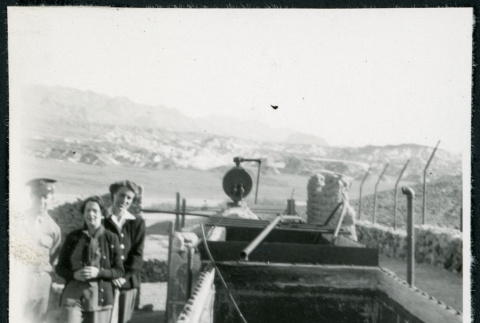 Photograph of three people standing next to Harmony Borax Works equipment in Death Valley (ddr-csujad-47-125)