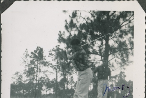 Man with golf club taking a swing (ddr-densho-321-386)