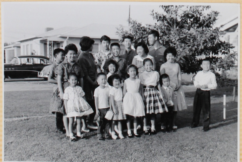 Large group of men, women and children in yard outside house (ddr-densho-522-62)