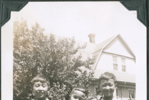 Photo of three boys holding a puppy (ddr-densho-483-1205)