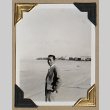 Man in a suit stands on a beach (ddr-densho-404-314)