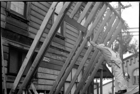 Group of men lifting framing alongside building (ddr-densho-426-2162)