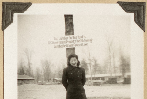 Mits poses next to a lumber sign (ddr-densho-542-403)