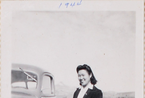 Woman standing next to car, Heart Mountain in background (ddr-densho-464-39)