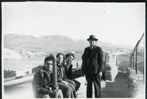 Photograph of four people next to Harmony Borax Works equipment in Death Valley (ddr-csujad-47-126)