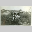 Two children sitting on a stump (ddr-densho-182-65)