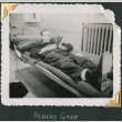 Man laying in bunk, reading (ddr-densho-434-185)