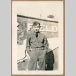 Japanese American soldier poses in front of sign (ddr-densho-368-491)