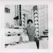 Tomoye Takahashi standing by product display at Gift Show (ddr-densho-426-1087)