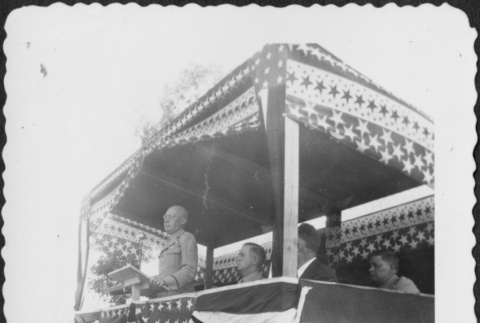 Man at podium on stage giving speech (ddr-densho-434-394)