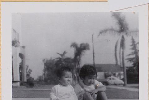 Susan and Leslie Shiomi sitting on lawn (ddr-densho-522-365)