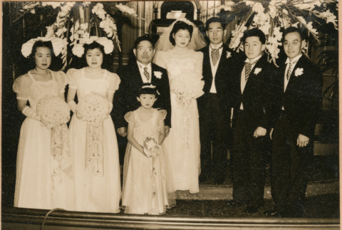 Henri Takahashi and Tomoye (Nozawa) Takahashi standing at altar with wedding party (ddr-densho-410-485)