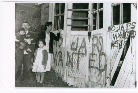 Nagaishi family standing outside garage with graffiti (ddr-densho-459-10)