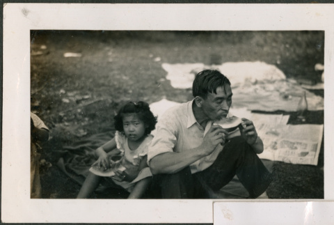 Man and girl eating watermelon (ddr-densho-316-402)