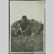 Japanese American soldier sitting in the grass (ddr-densho-201-387)