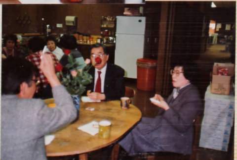 Three people at a table with a table in the background (ddr-densho-426-1279)