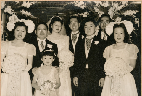 Henri Takahashi and Tomoye (Nozawa) Takahashi standing at altar with wedding party (ddr-densho-410-486)